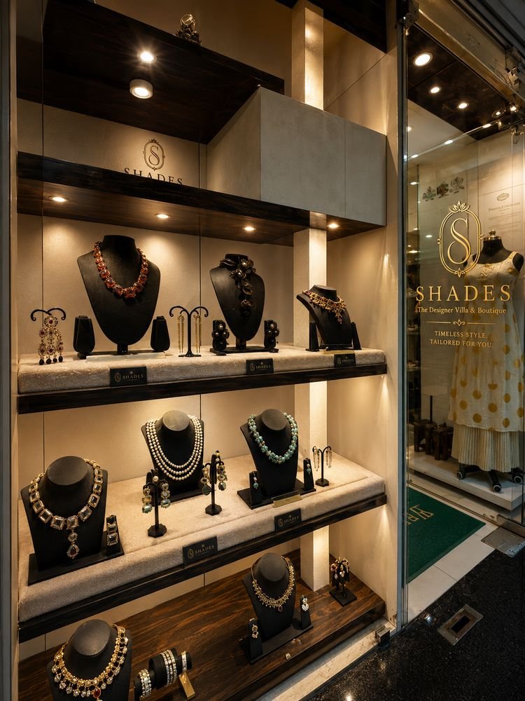Shades jewellery window with necklaces on black busts and branded plaques
